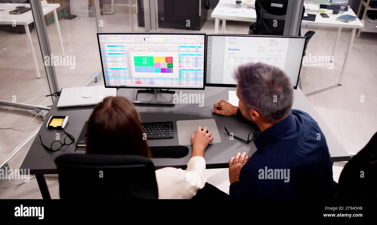 Più codificatori medici che lavorano su fogli di calcolo con i computer Foto Stock