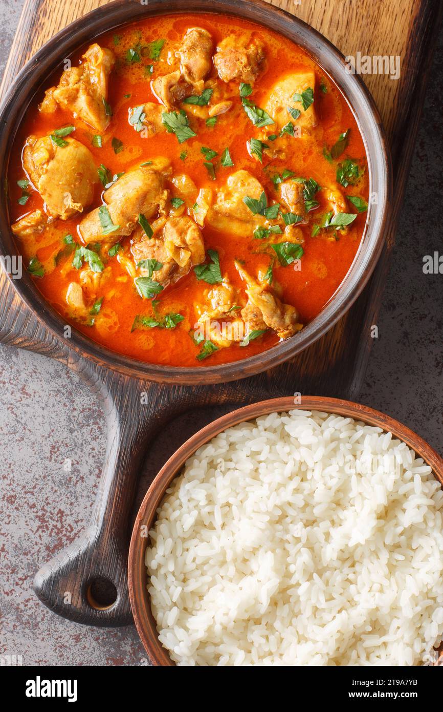 Lahori Chicken un piatto indiano di curry di pollo dal Pakistan servito con riso basmati per primo piano sulla tavola di legno sul tavolo. Vista dall'alto verticale da ab Foto Stock