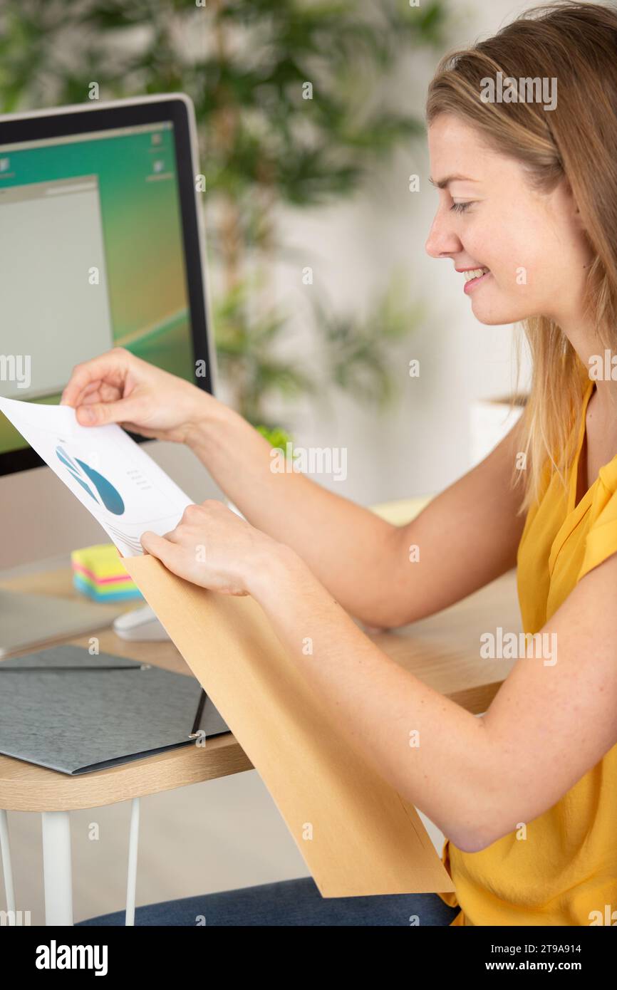 felice imprenditore che mette il documento in una busta Foto Stock