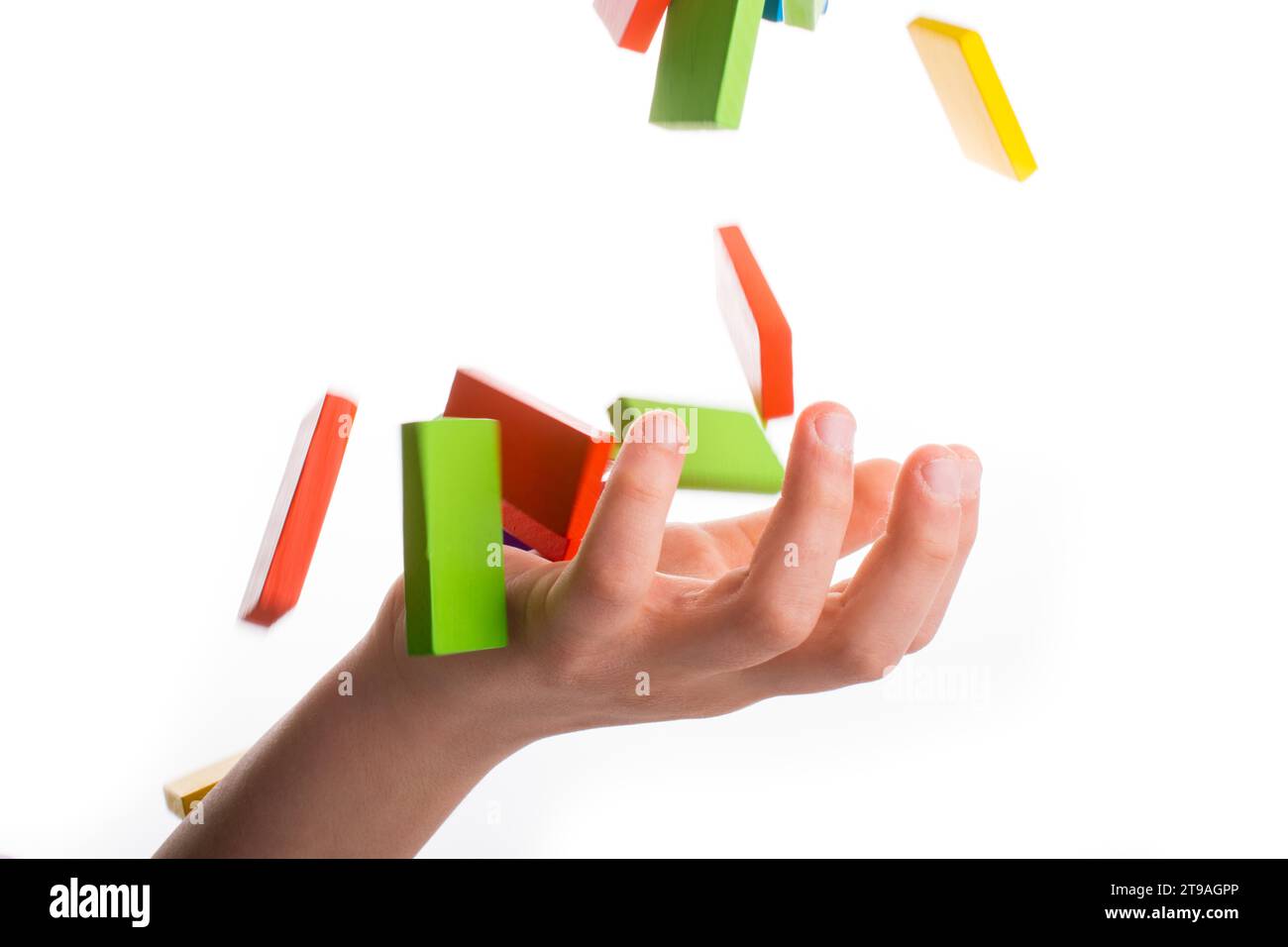 Caduta di domino colorato su una mano Foto Stock