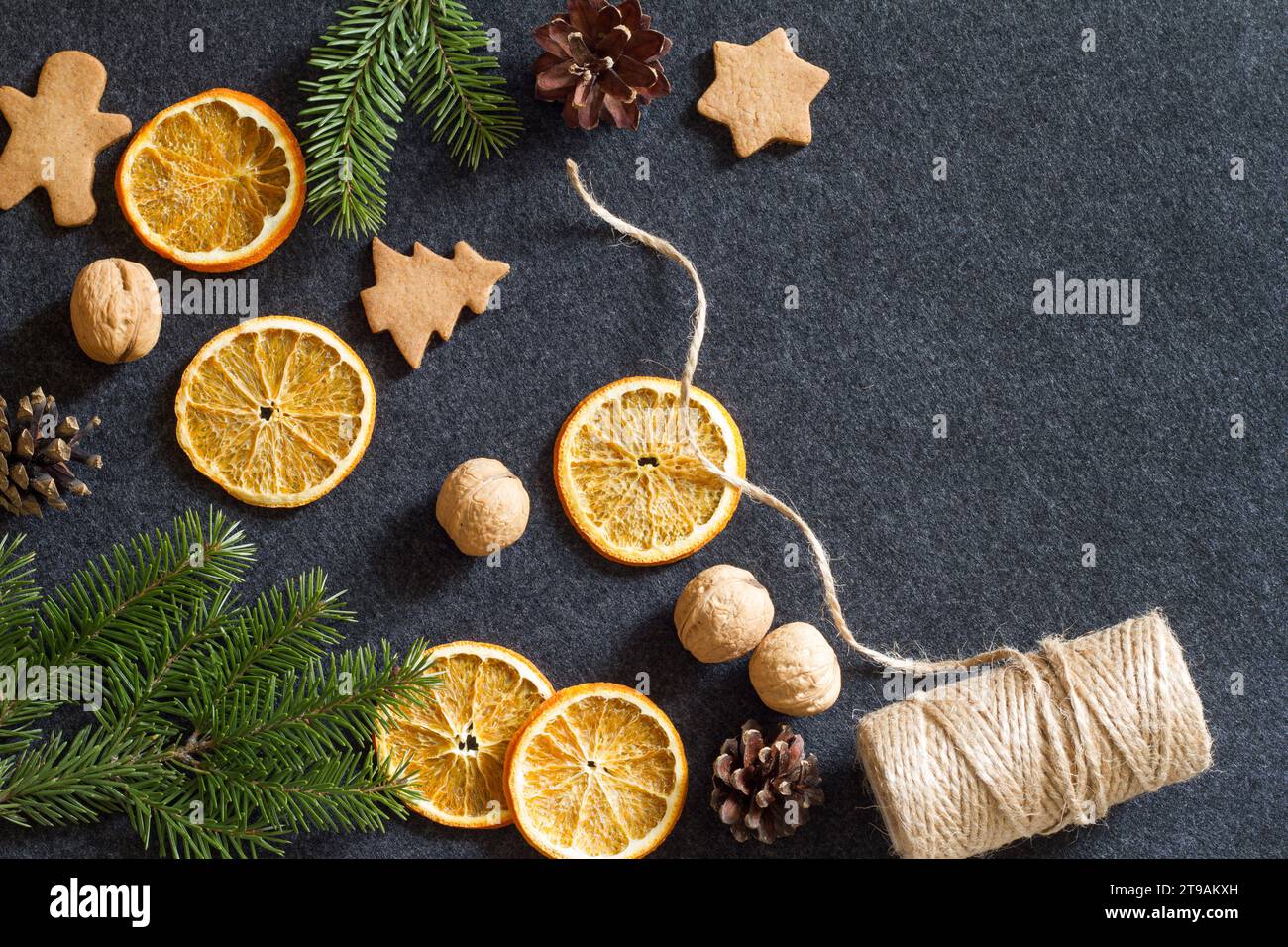 Sfondo natalizio, arancia secca, coni, noci e biscotti, decorazioni naturali per l'albero di natale Foto Stock