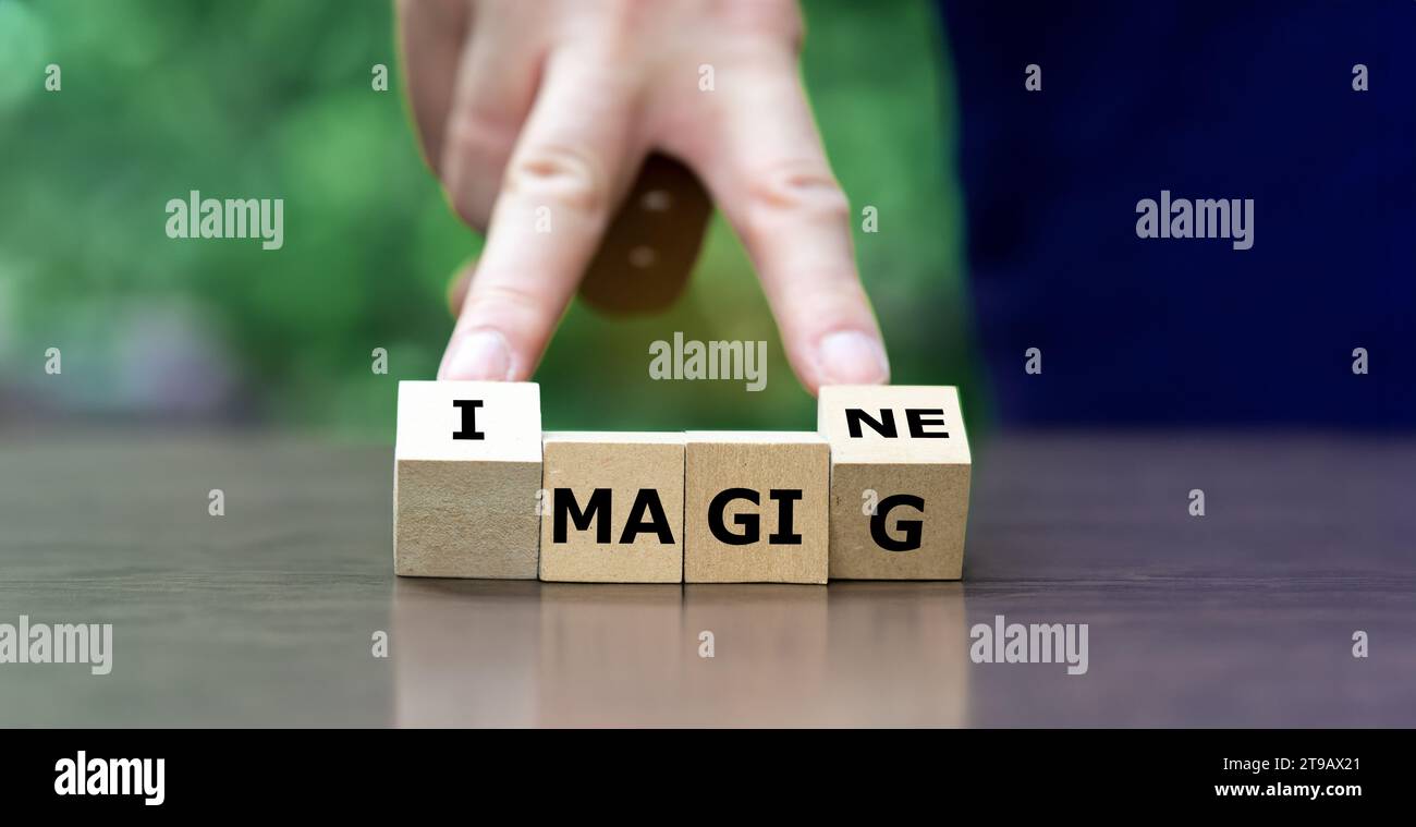 La mano gira cubi di legno e cambia la parola magia per immaginare. Foto Stock