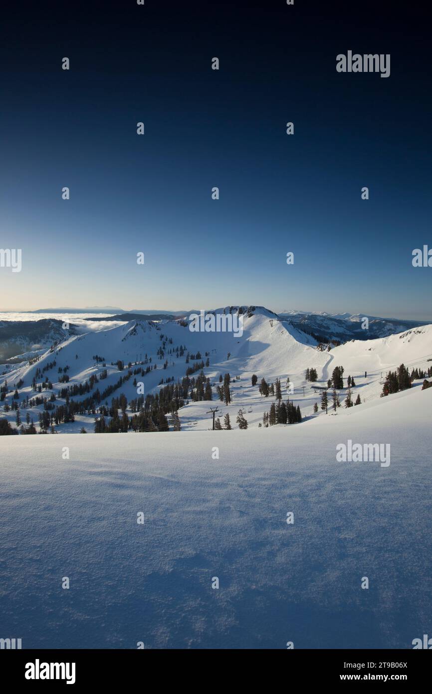 Vista panoramica delle montagne e della neve fresca all'alba. Foto Stock