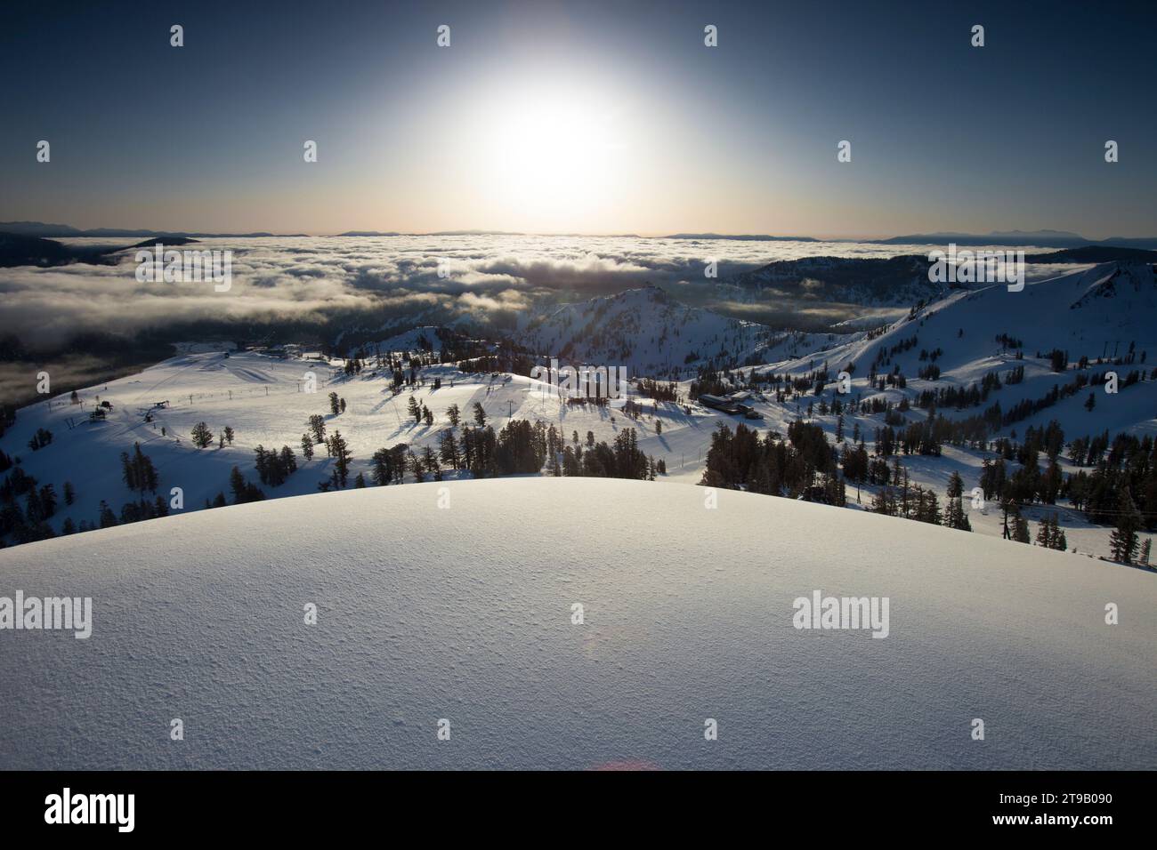 Vista panoramica delle montagne e della neve fresca all'alba. Foto Stock