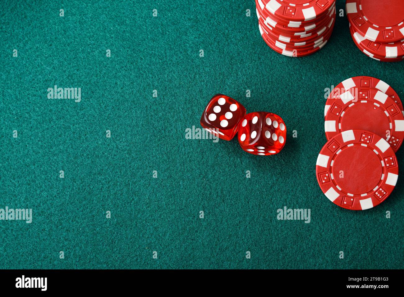 Sfondo di gioco dei dadi del casinò con due e chip rossi isolati su un tappeto di feltro verde. Vista dall'alto. Foto Stock