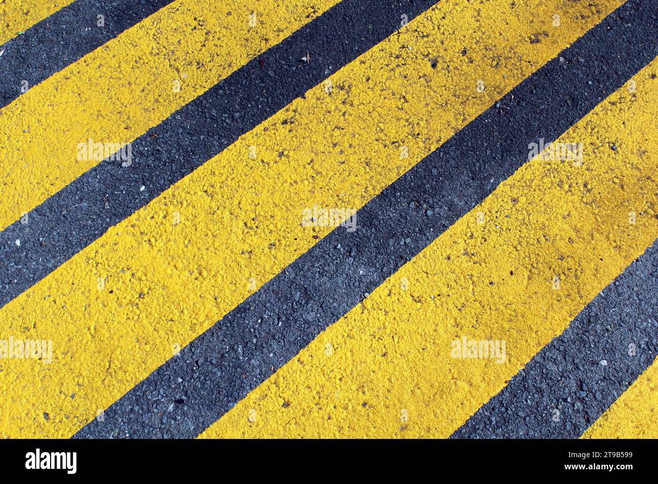 Linee di pericolo parallele gialle verniciate su asfalto Foto Stock