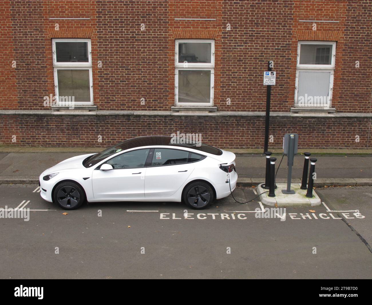 Sui punti di ricarica per veicoli stradali a Leyton, Londra, Regno Unito. Un'auto Tesla collegata a un punto di ricarica per veicoli elettrici gestito da un comune. Foto Stock