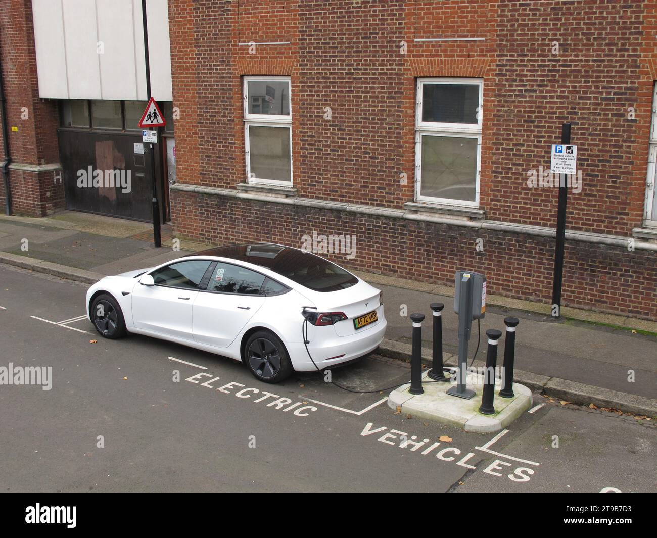 Sui punti di ricarica per veicoli stradali a Leyton, Londra, Regno Unito. Un'auto Tesla collegata a un punto di ricarica per veicoli elettrici gestito da un comune. Foto Stock