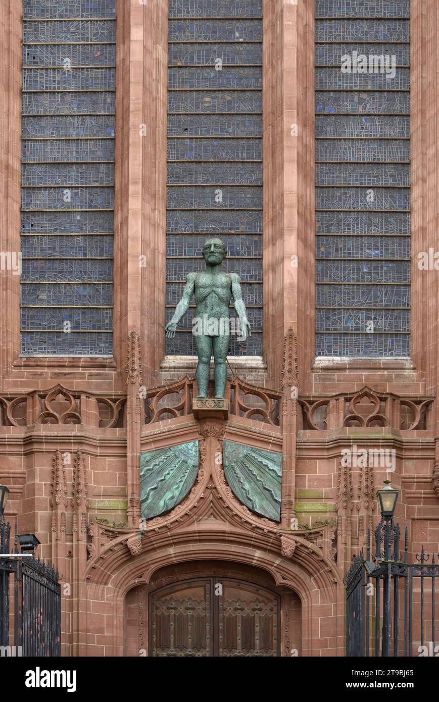 Scultura di Cristo risorto (1993) di Dame Elisabeth Frink sopra le porte occidentali e ingresso della cattedrale anglicana di Liverpool con opere in pietra gotica scolpite Foto Stock