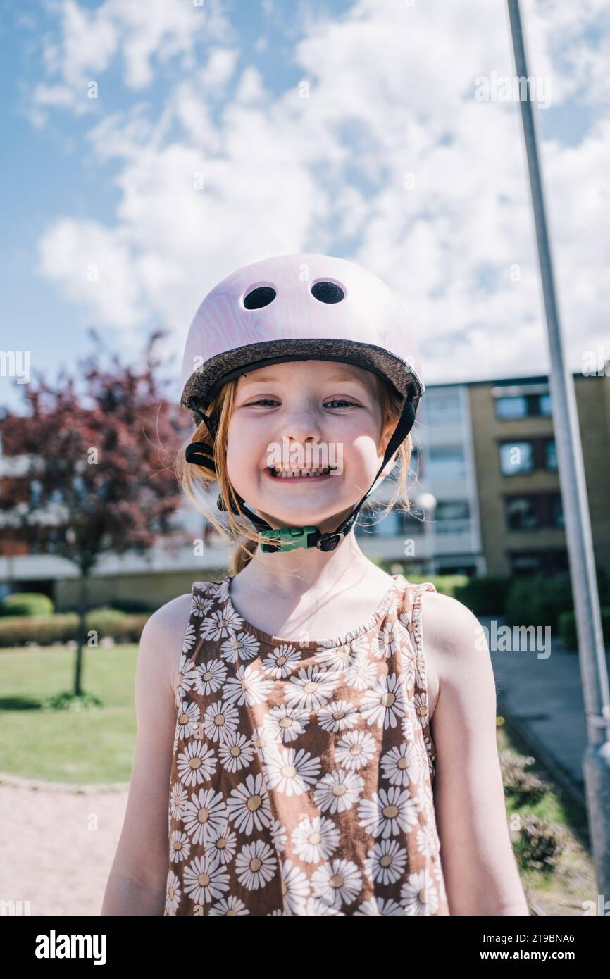 Ritratto di una ragazza felice che indossa un casco da ciclismo Foto Stock