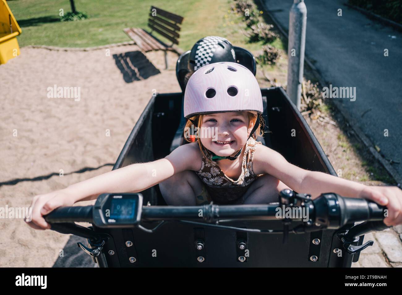 Ritratto di una ragazza felice che indossa un casco da ciclismo Foto Stock