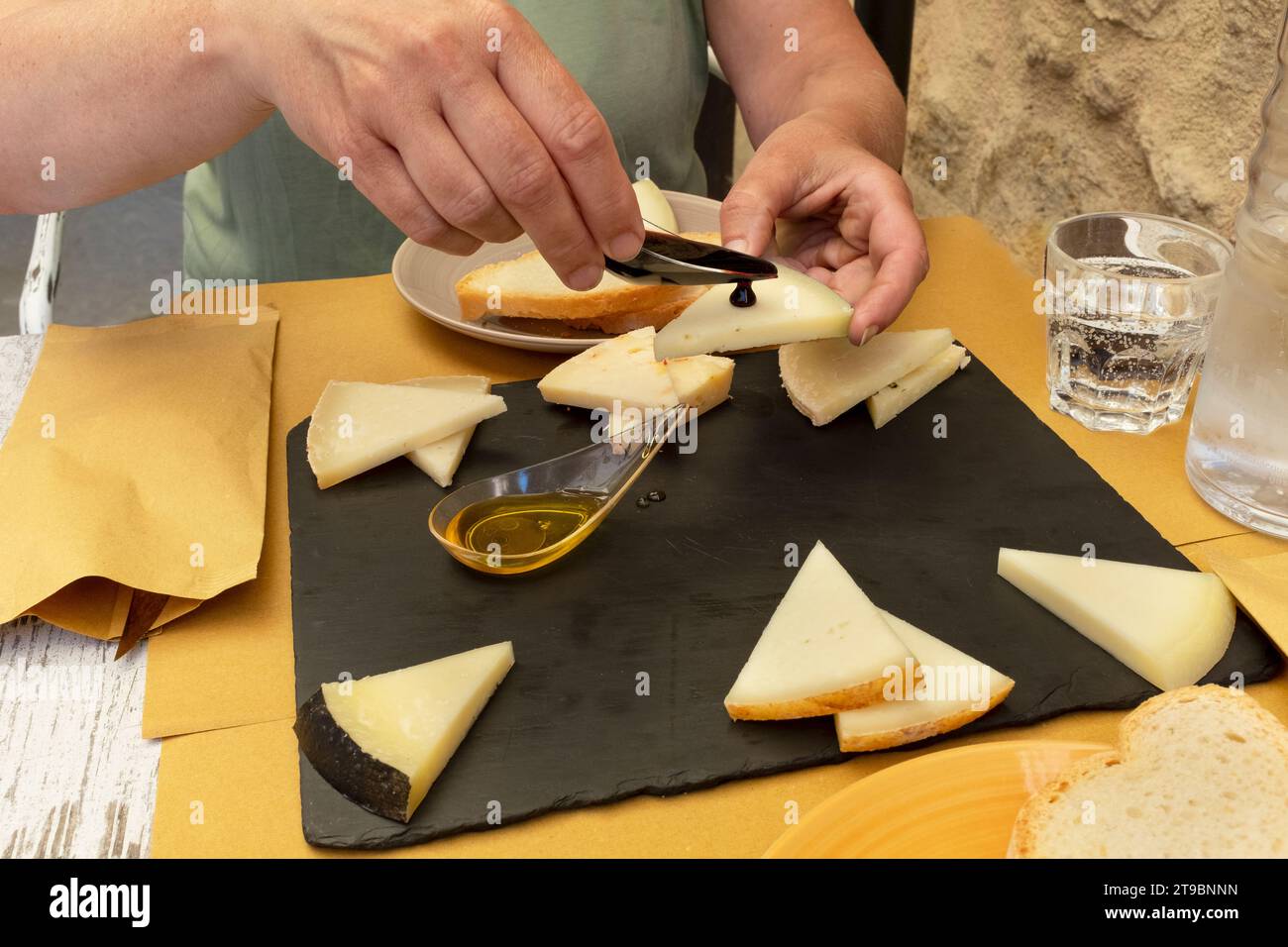 Mani di persona che preparano spuntini al formaggio Foto Stock