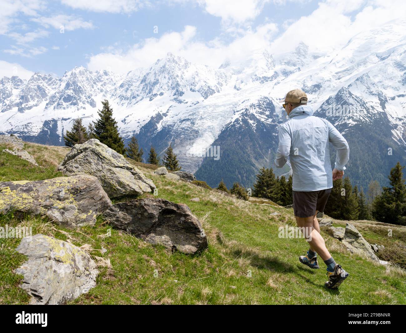 Uomo che fa escursioni vicino a montagne innevate Foto Stock