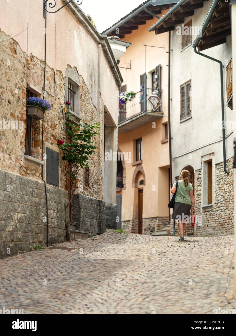 Donna che cammina in vicoli stretti della città vecchia Foto Stock