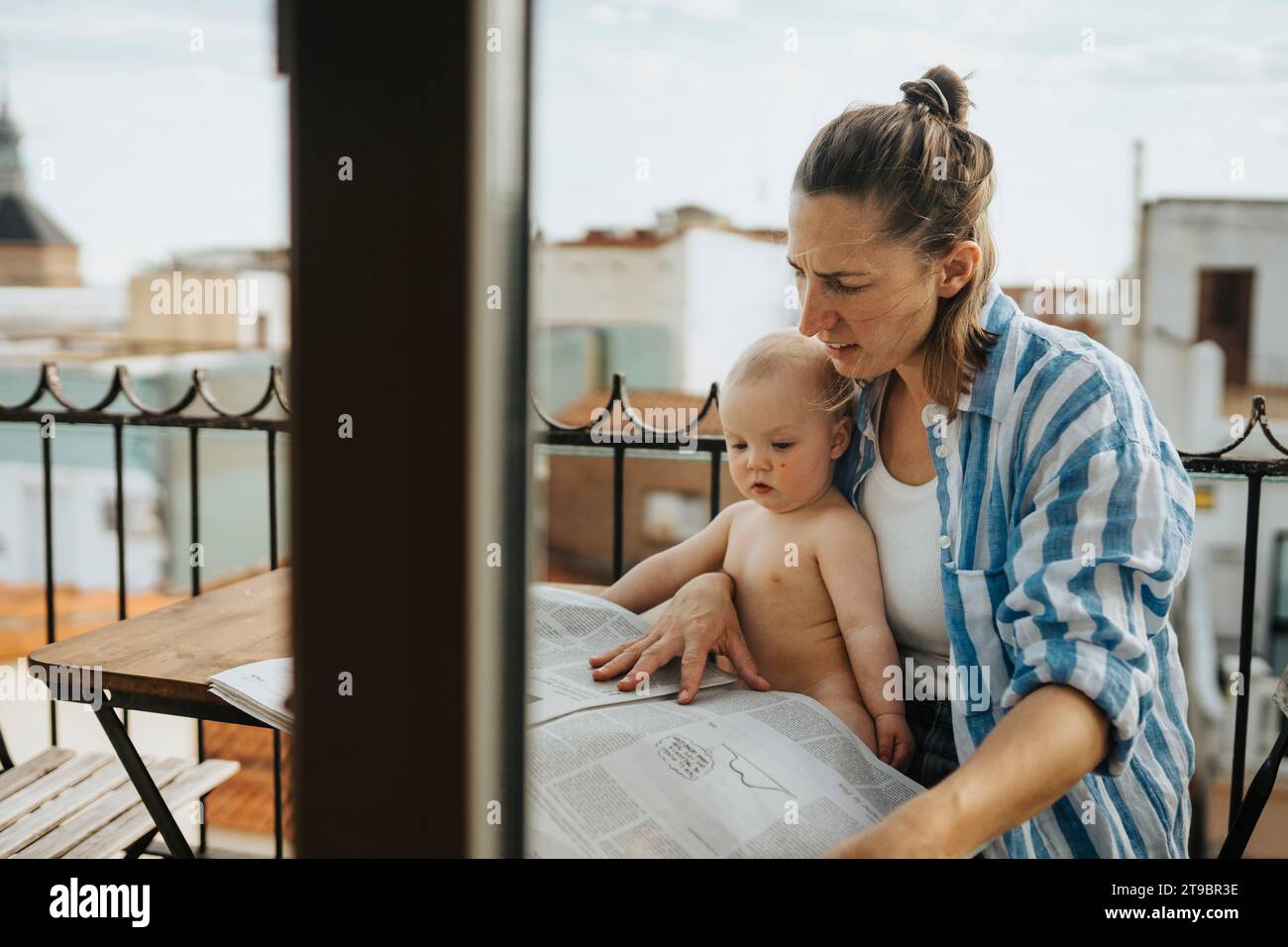 La madre si rilassa con il bambino sul balcone d'estate Foto Stock