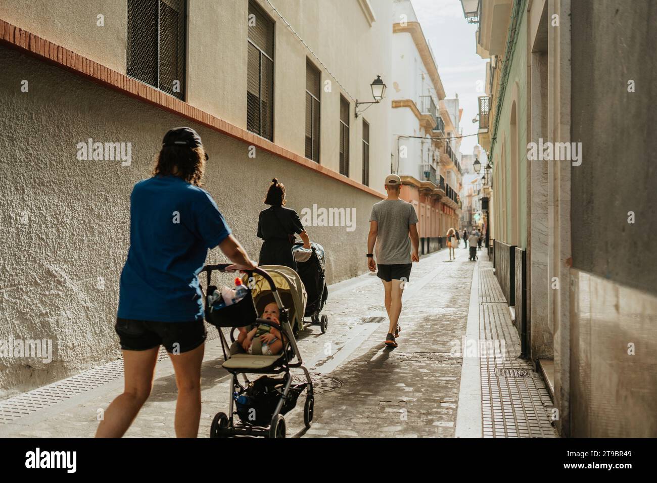 Genitori con bambini in passeggini che camminano in città Foto Stock