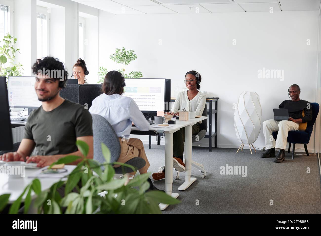 Persone sedute e che usano computer in ufficio Foto Stock
