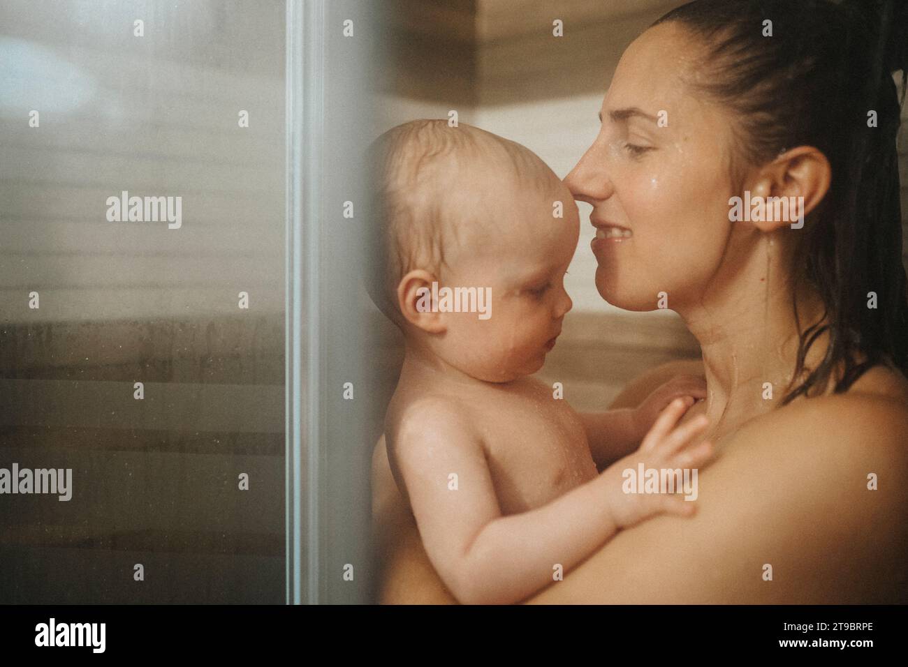Madre che fa la doccia con il bambino a casa Foto Stock