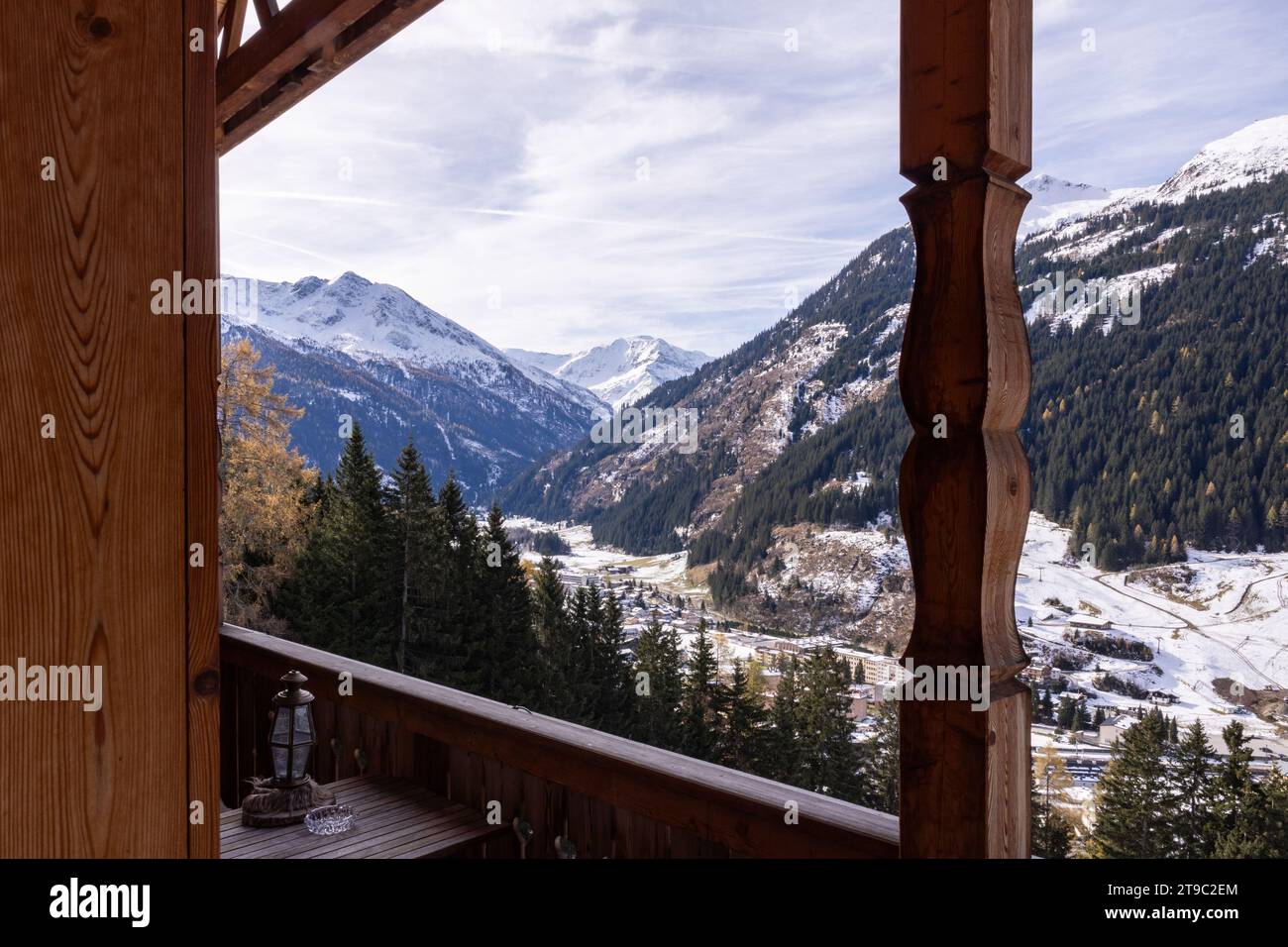Vista panoramica dal balcone di legno di una camera d'hotel sulle montagne alpine innevate e il cielo nuvoloso, Austria Foto Stock