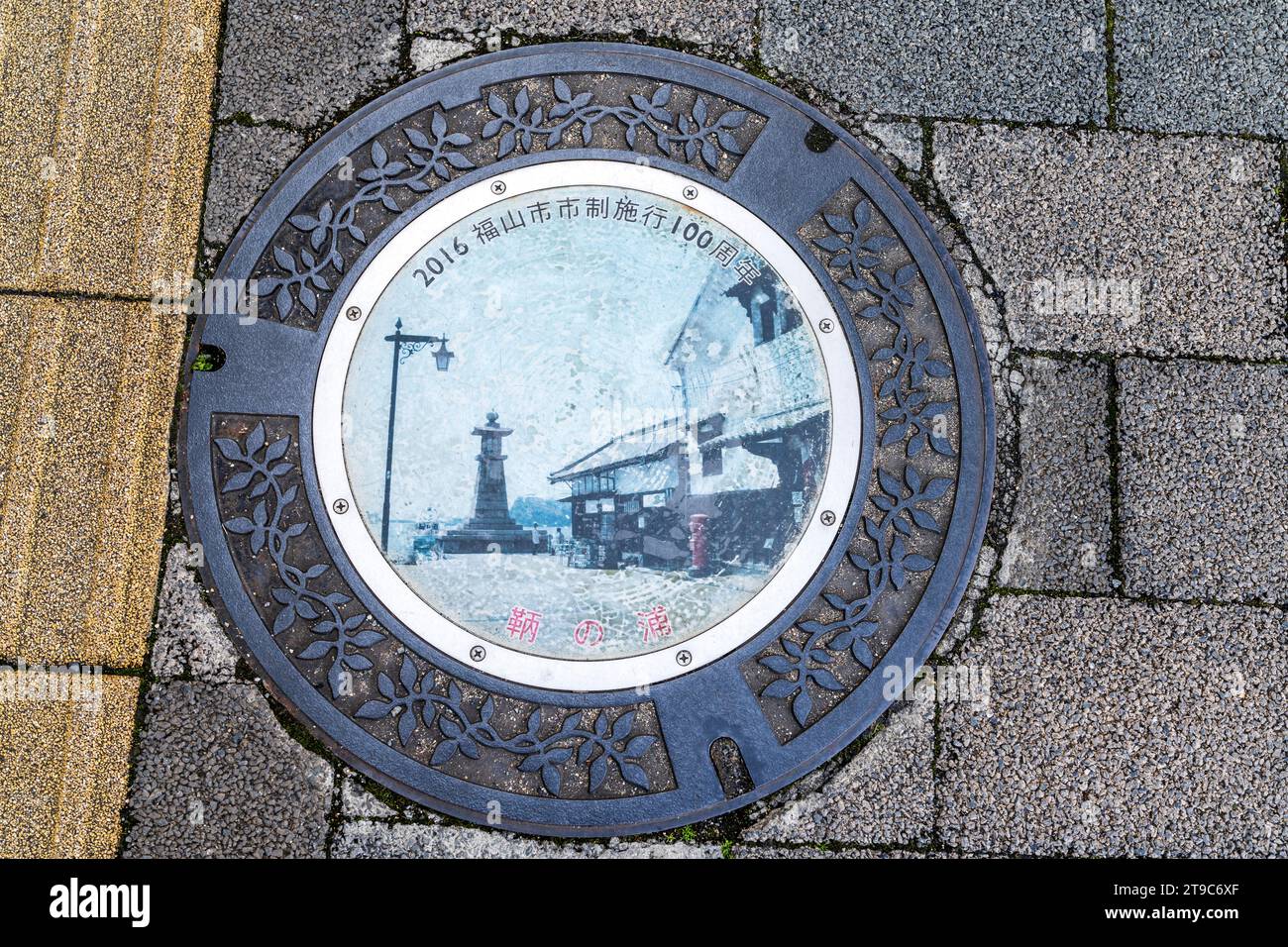 Copertura per tombini giapponesi. La copertina illustrata presenta una scena di strada vecchio stile dei primi del 1916. Le coperture dei tombini sono diventate un'opera d'arte in Giappone. Foto Stock