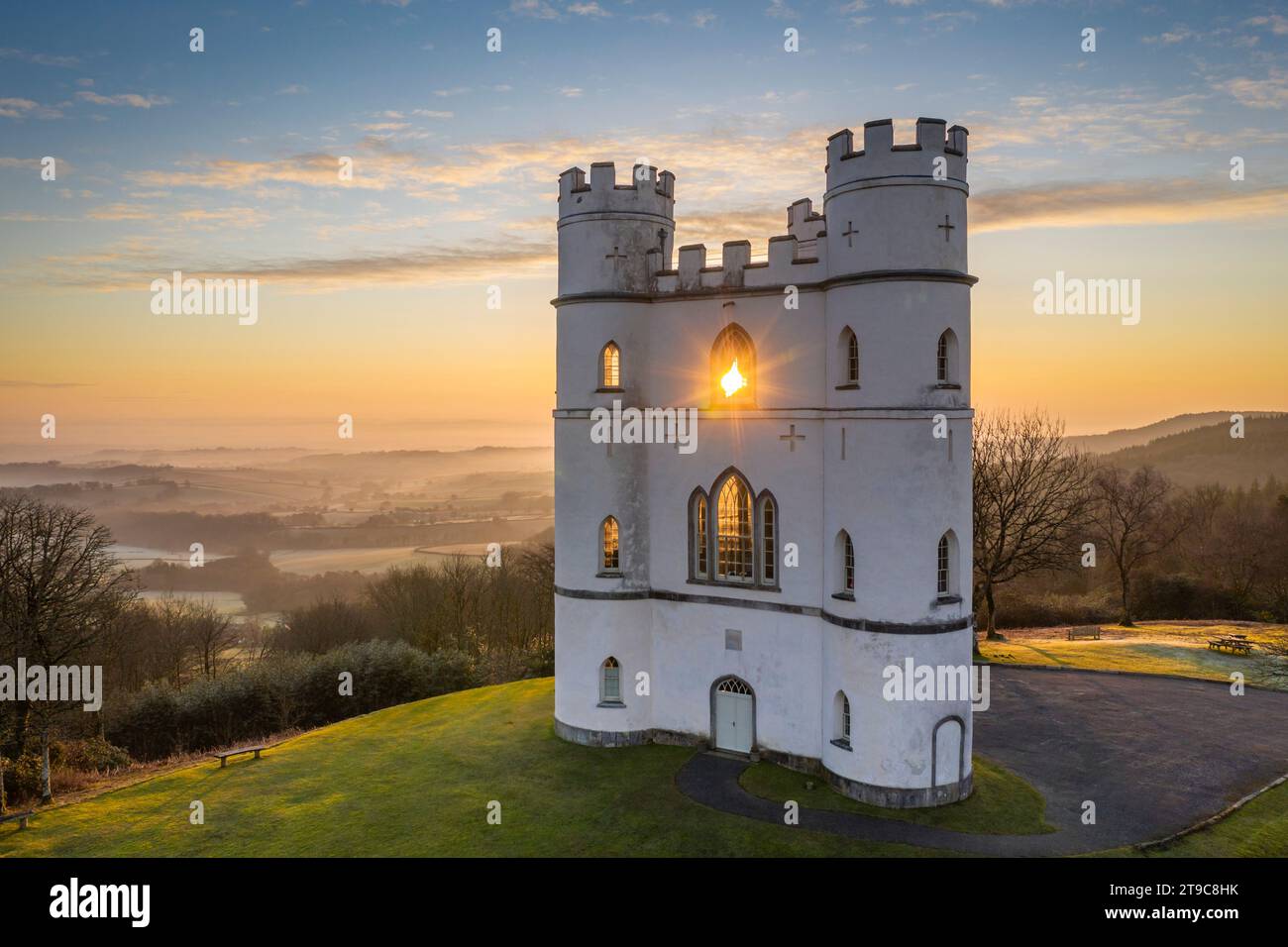 Il sole sorge attraverso Haldon Belvedere (Lawrence Castle), Devon, Inghilterra. Inverno (marzo) 2021. Foto Stock