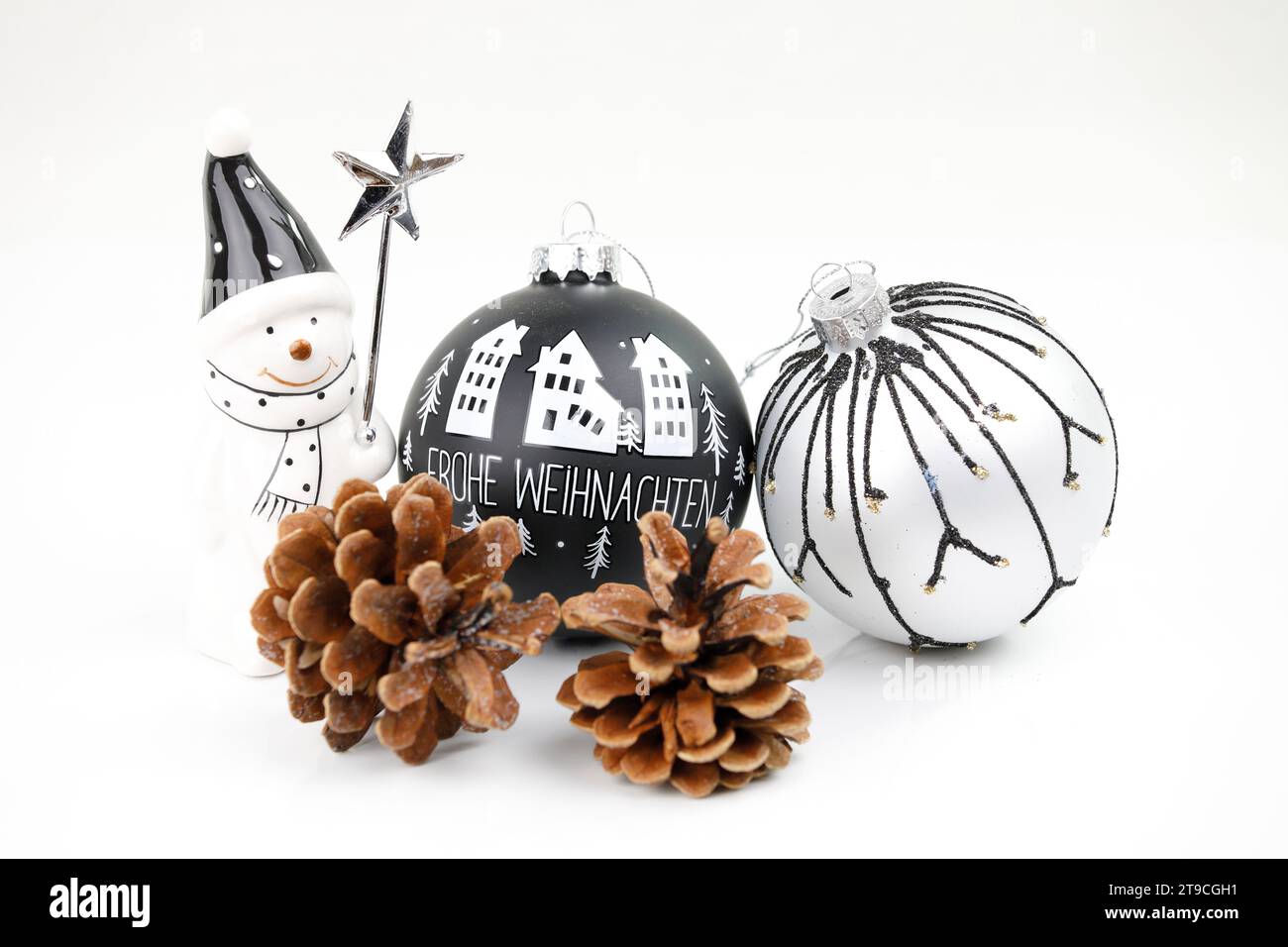 Due moderni bauble per alberi di Natale in bianco e nero, un uomo con una stella e coni di pino Foto Stock