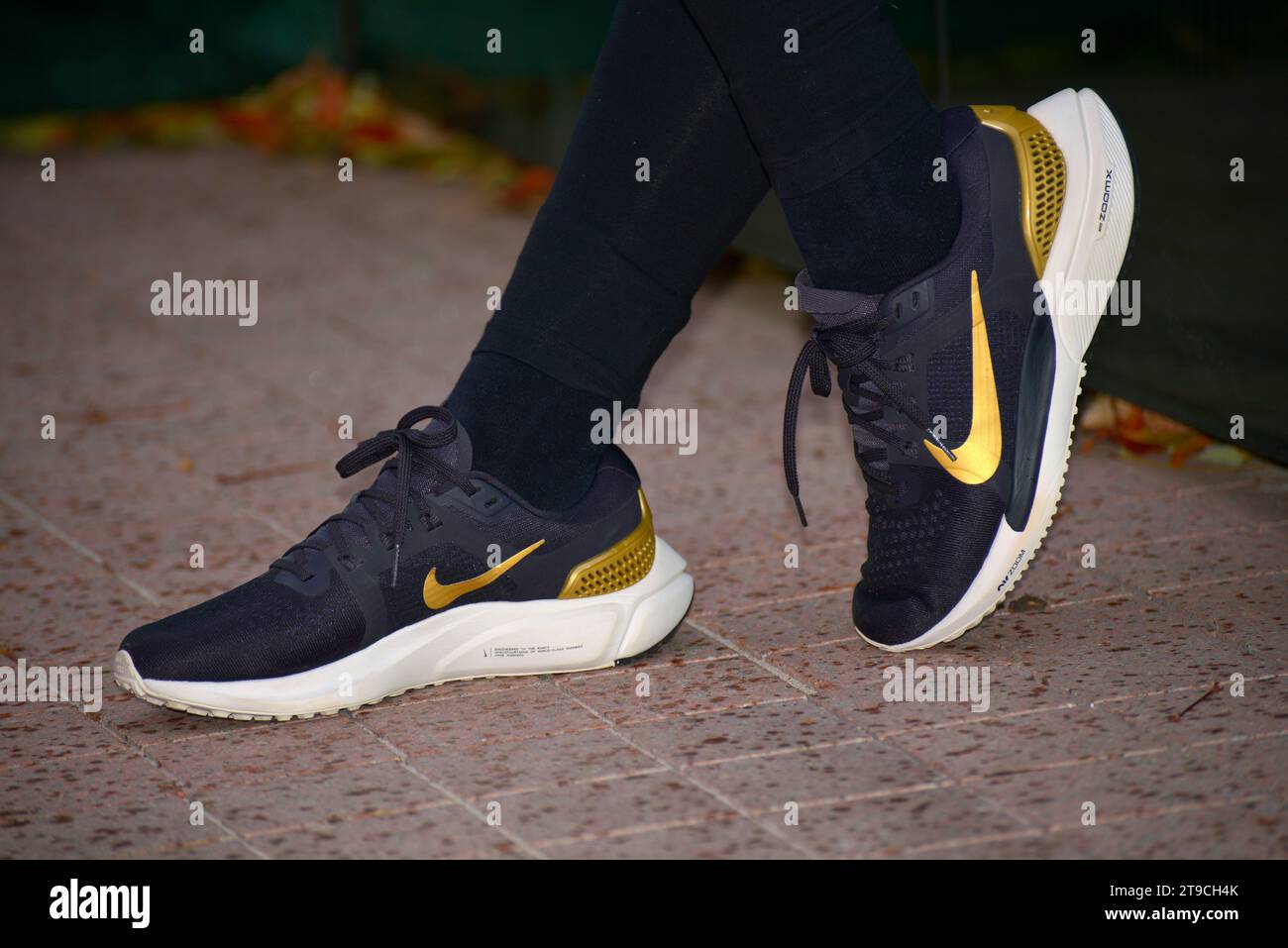 La ragazza indossa le nuove scarpe sportive Nike blu scuro, le sneakers corrono con lo Swoosh giallo Foto Stock