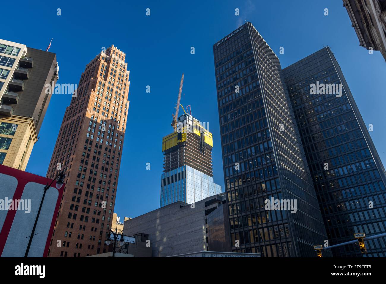 Il grattacielo Hudson di Detroit, ancora sormontato da una gru e da livelli di costruzione vestiti di giallo a ottobre 2023, si erge accanto alla già restaurata Book Tower in mattoni rossi nel centro di Detroit, Michigan, Stati Uniti. La nuova torre sorge sul sito dell'ex grande magazzino J.L. Hudson's, demolito nel 1998 nella più grande implosione controllata della storia degli Stati Uniti a quel tempo. La vicina Book Tower era stata riaperta solo nell'aprile 2023 dopo una restaurazione di sette anni del costo di circa 300 milioni di dollari. Foto Stock