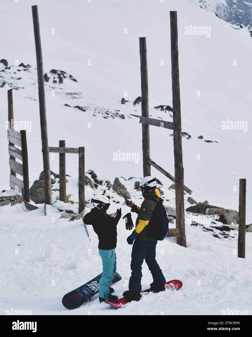 una coppia viene catturata in un momento d'amore beato mentre naviga su una pista innevata insieme sugli sci. Il paesaggio invernale offre uno sfondo mozzafiato, Foto Stock