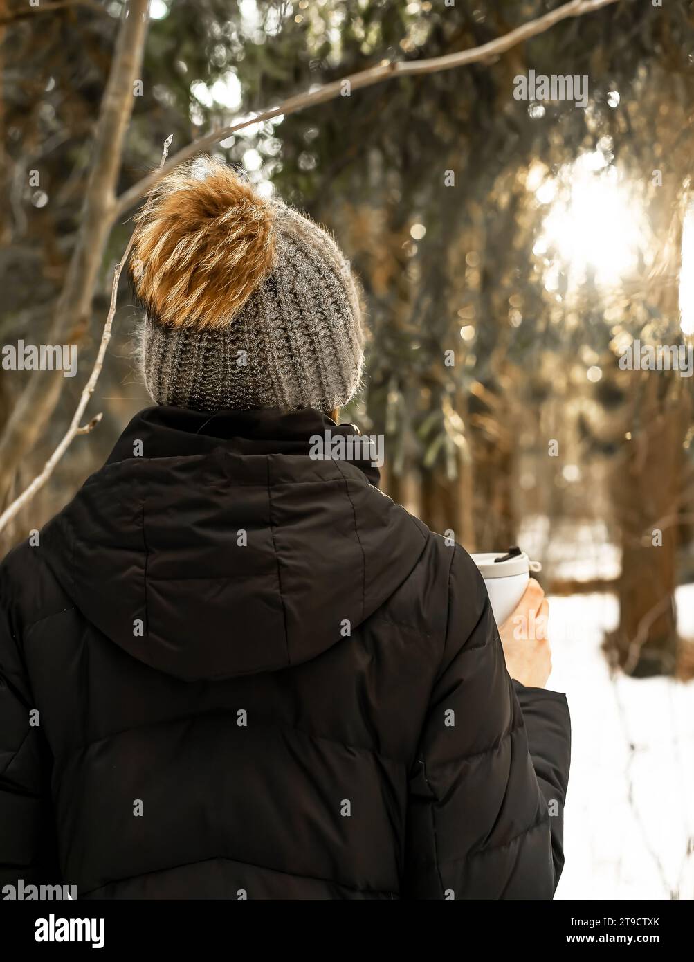 Donna con cappello di lana lavorato a maglia, berretto con pompon, tazza termica in inverno Foto Stock