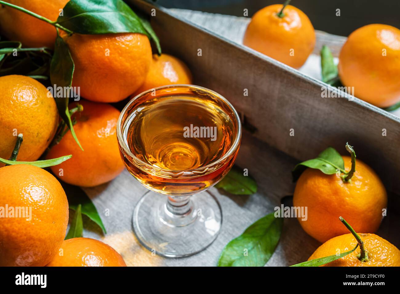 Shot di liquore al mandarino e primi piani di mandarini freschi Foto Stock