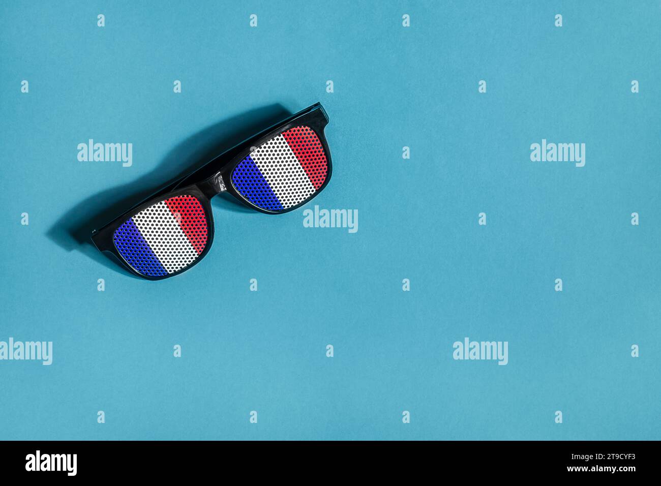 Occhiali da sole nei colori della bandiera francese su sfondo blu, vista dall'alto, Festa Nazionale francese Foto Stock