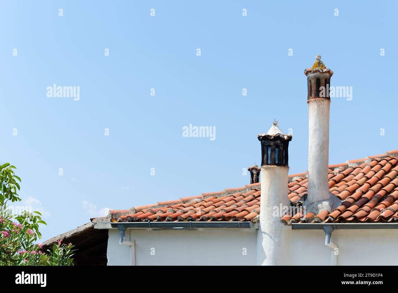 Tetto piastrellato marrone chiaro con pile di camini Foto Stock