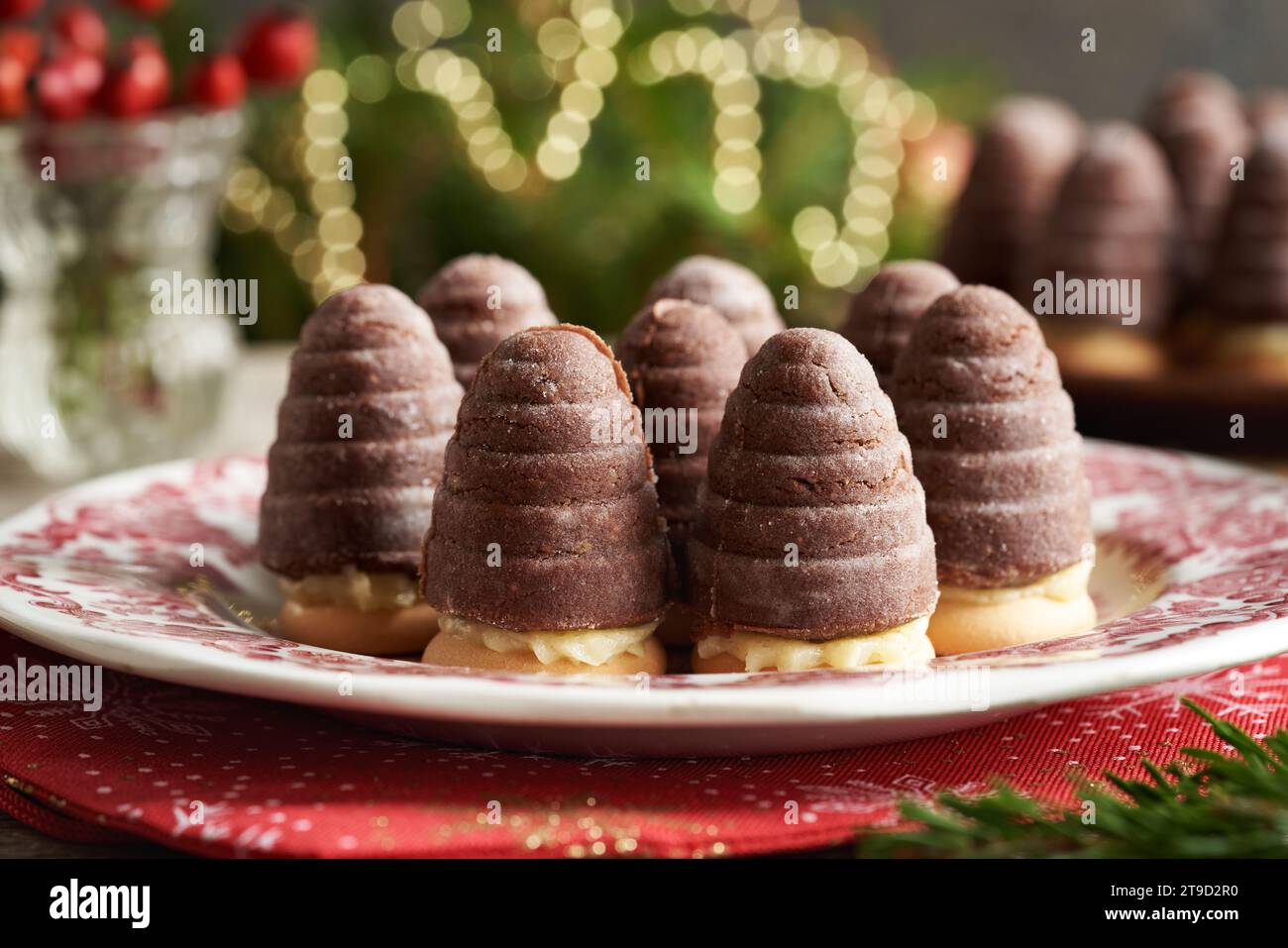 Nidi WASP e alveari - tradizionali biscotti di Natale cechi senza cottura riempiti con crema di eggnog con luci sullo sfondo Foto Stock