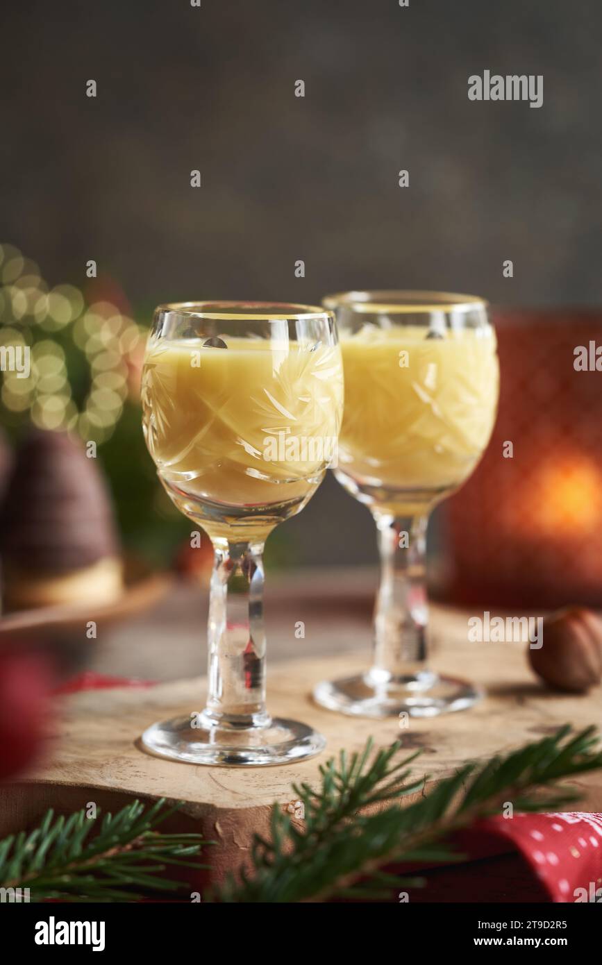 Due bicchieri di eggnog con biscotti di Natale e rami d'albero sullo sfondo Foto Stock