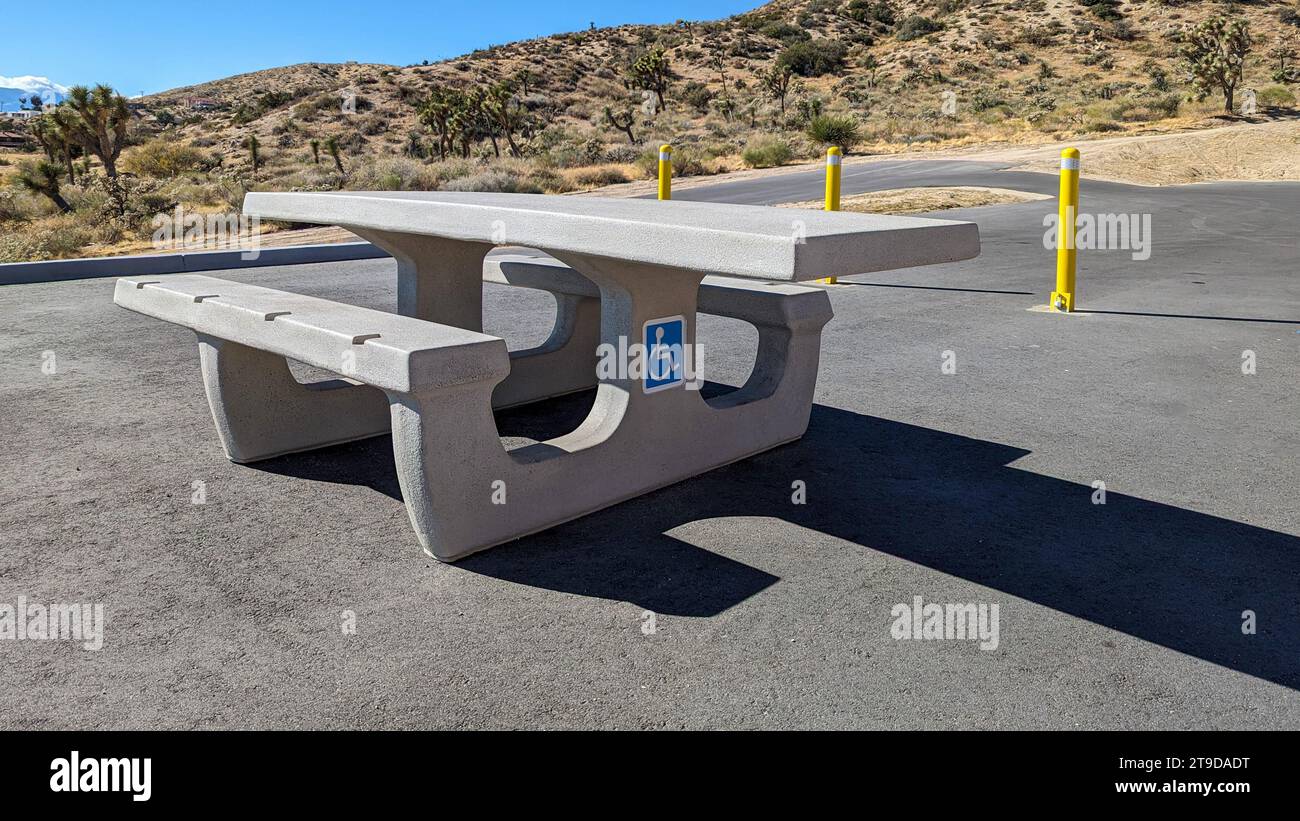 Tavolo da picnic in cemento accessibile con sedia a rotelle nell'area parcheggio di un'area ricreativa nel deserto Foto Stock