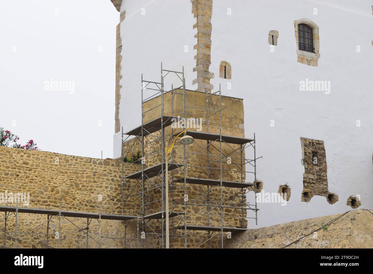 La foto non curata mostra impalcature per il rinnovo e la ristrutturazione di vecchi edifici storici, le mura della torre del castello Foto Stock