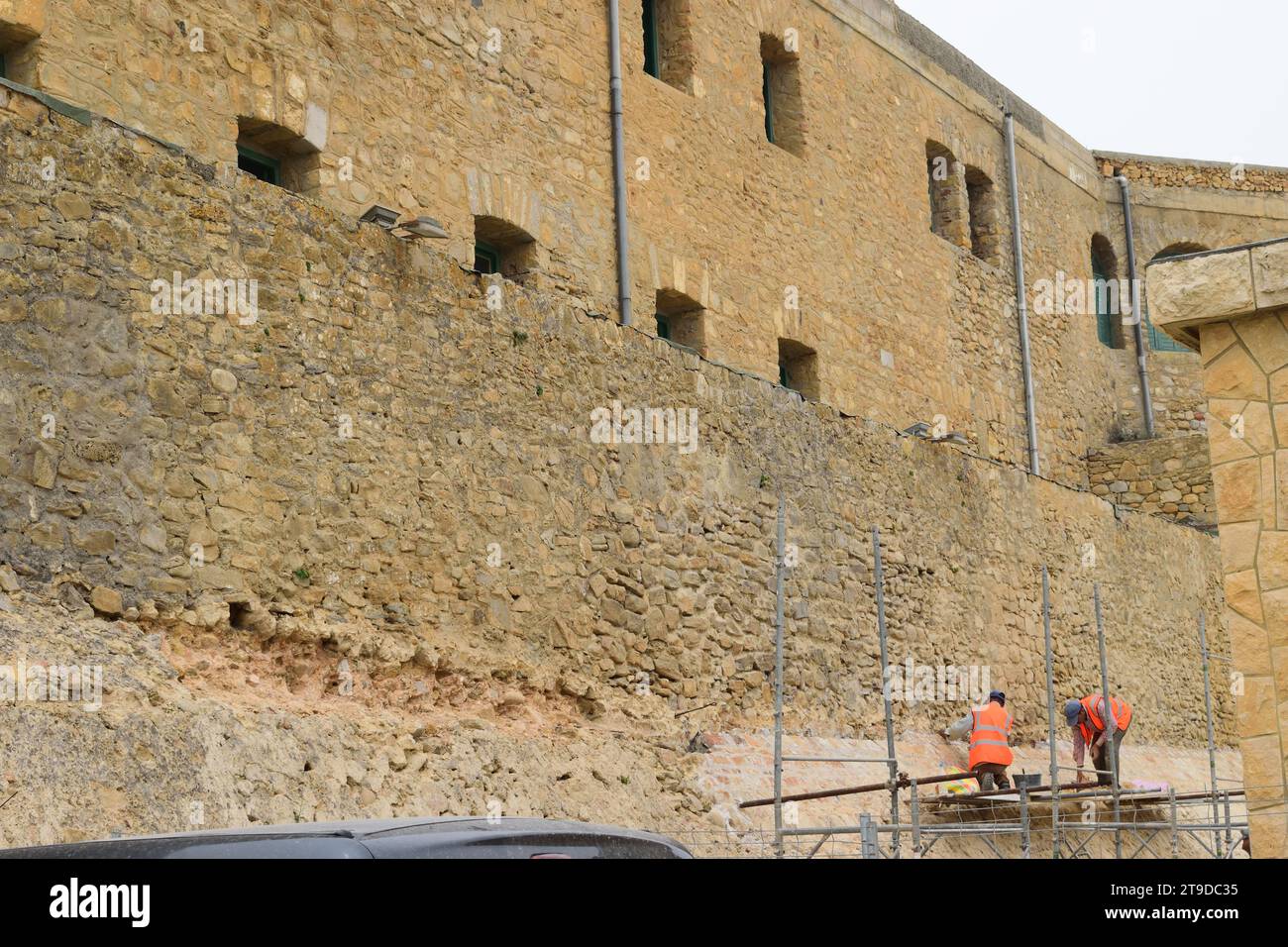 foto non curata di lavoratori che lavorano al rinnovo e alla ristrutturazione di edifici storici antichi mura del castello Foto Stock