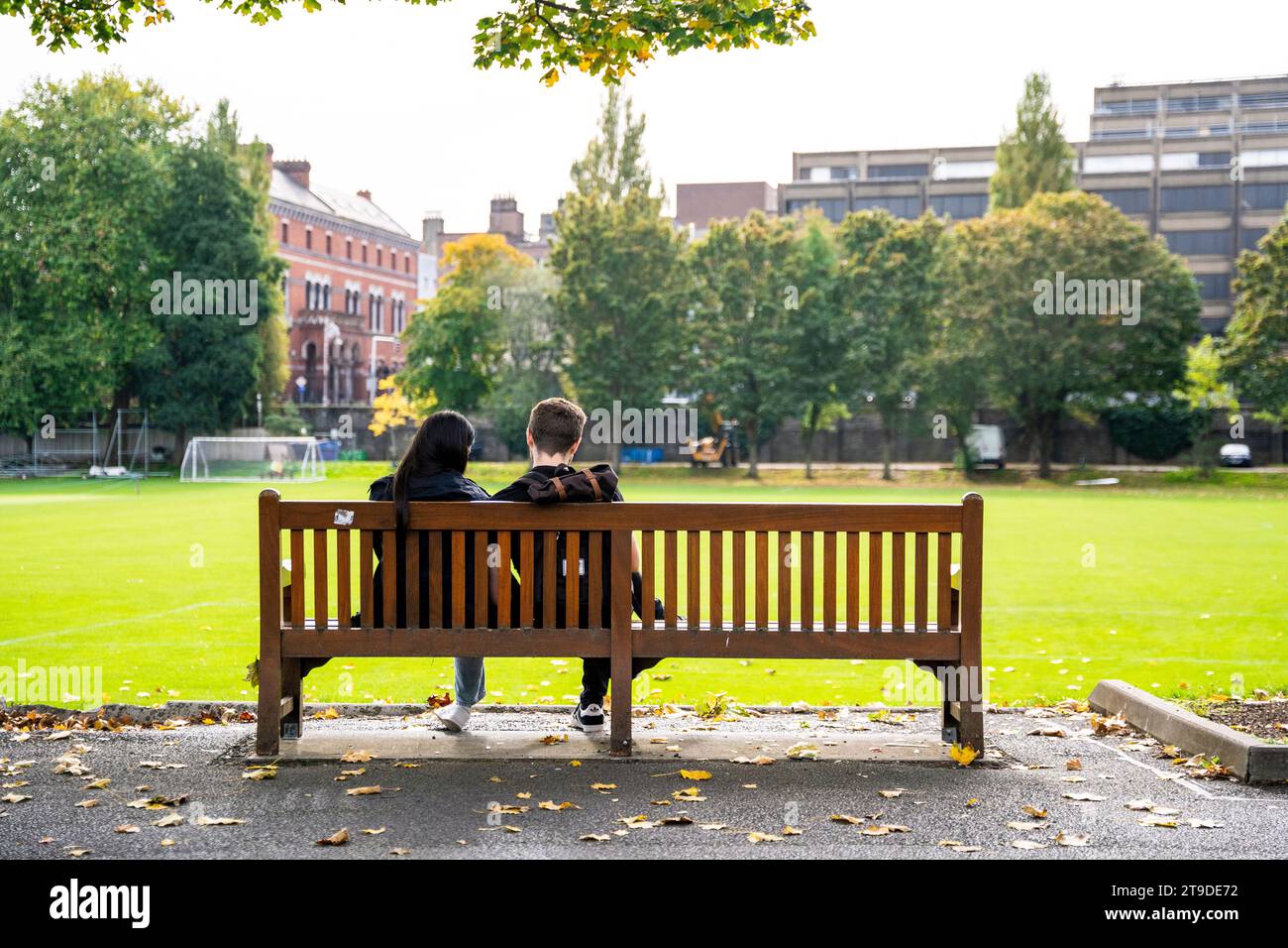 Una coppia di fronte al College Park, nel campus del Trinity College, nel centro di Dublino, Irlanda, con i turisti in una giornata di sole Foto Stock
