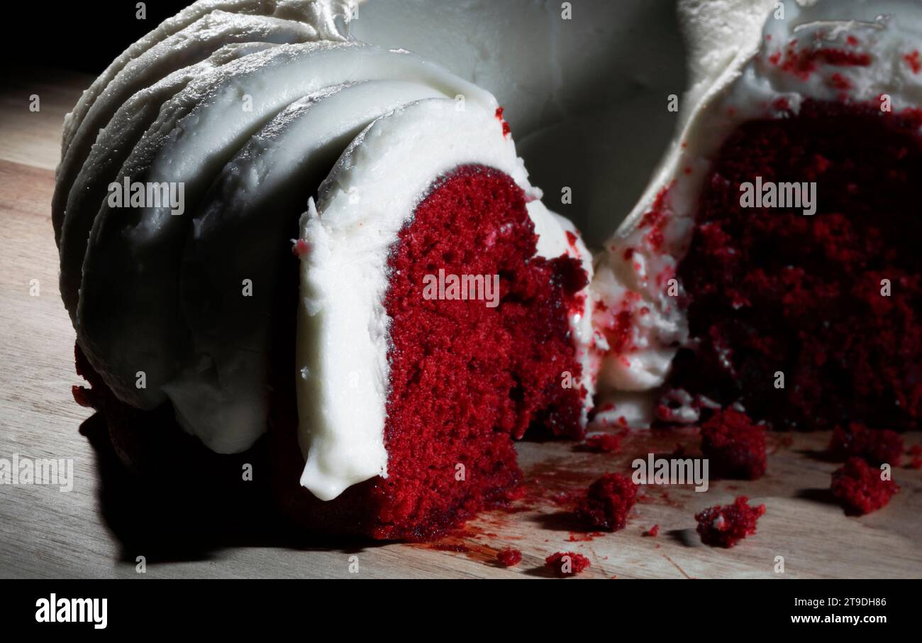 Torta di velluto rosso umida e crumblign su un tavolo di legno Foto Stock
