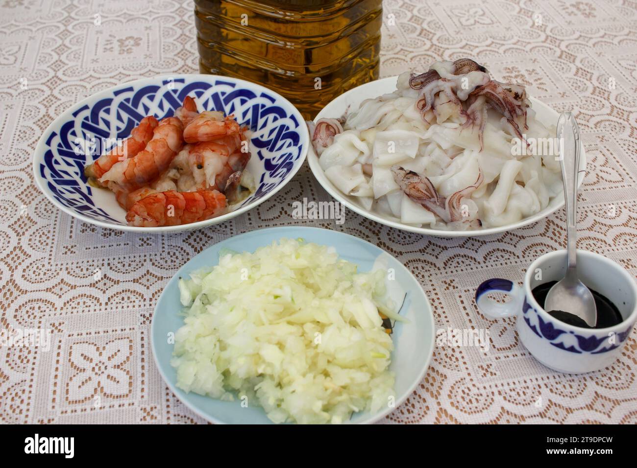 cipolla, inchiostro, calamari, gamberetti e olio d'oliva sono alcuni degli ingredienti per cucinare un delizioso riso nero a casa Foto Stock