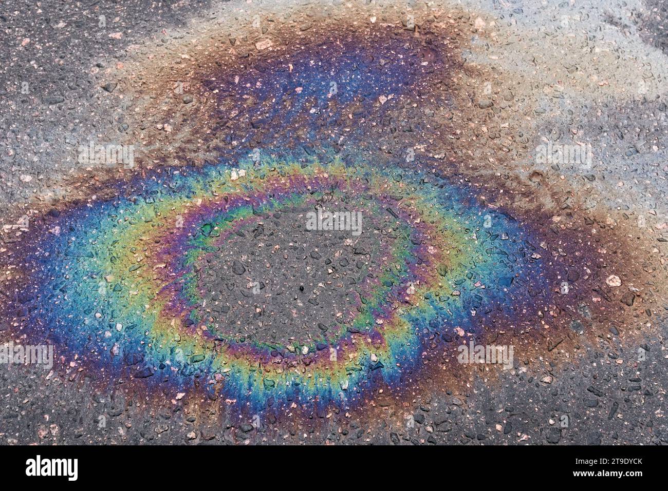 Macchie di carburante o olio su asfalto bagnato in una giornata di pioggia. Il concetto di inquinamento ambientale. Foto Stock