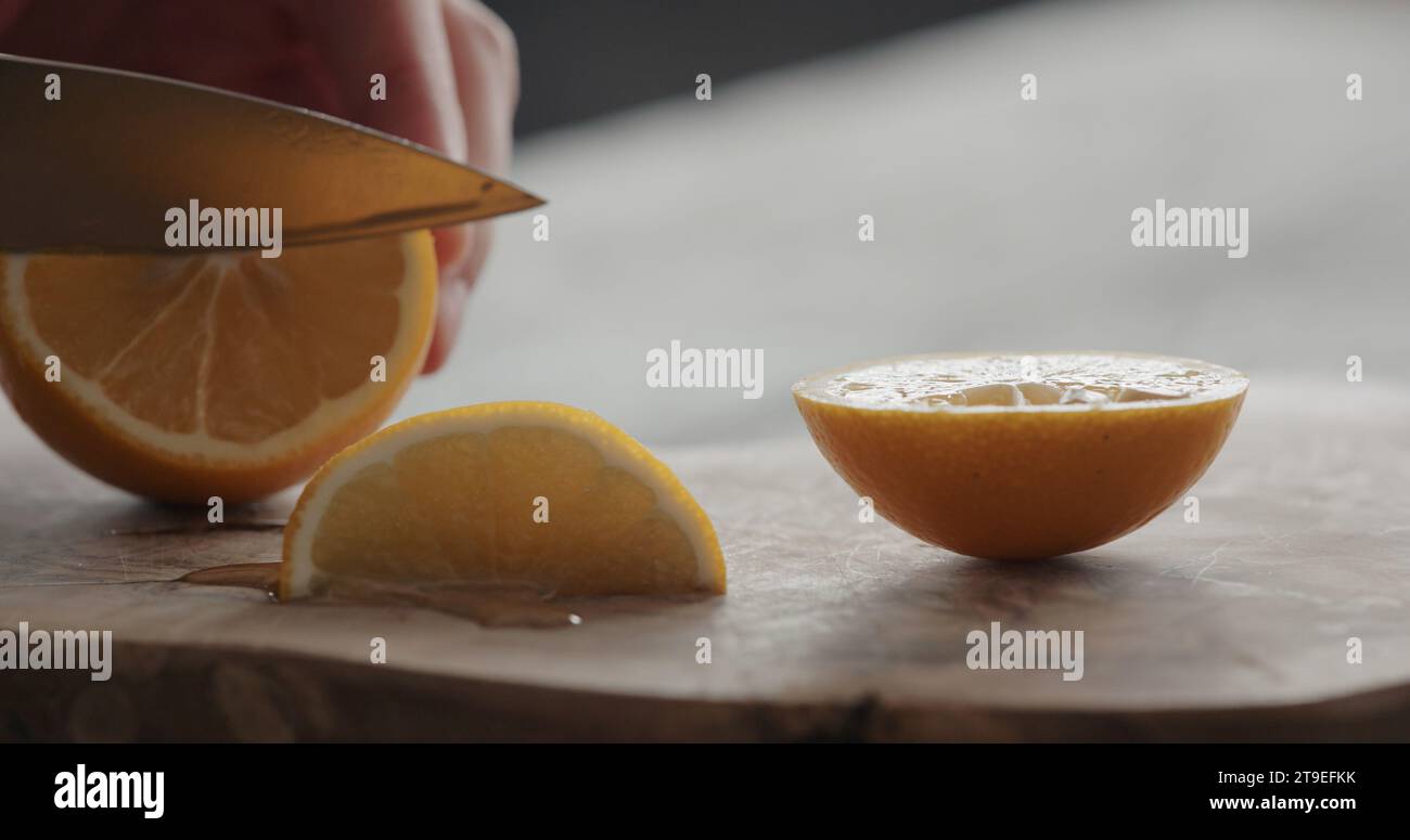 uomo taglio limone dolce su tavola di olive, foto ampia Foto Stock