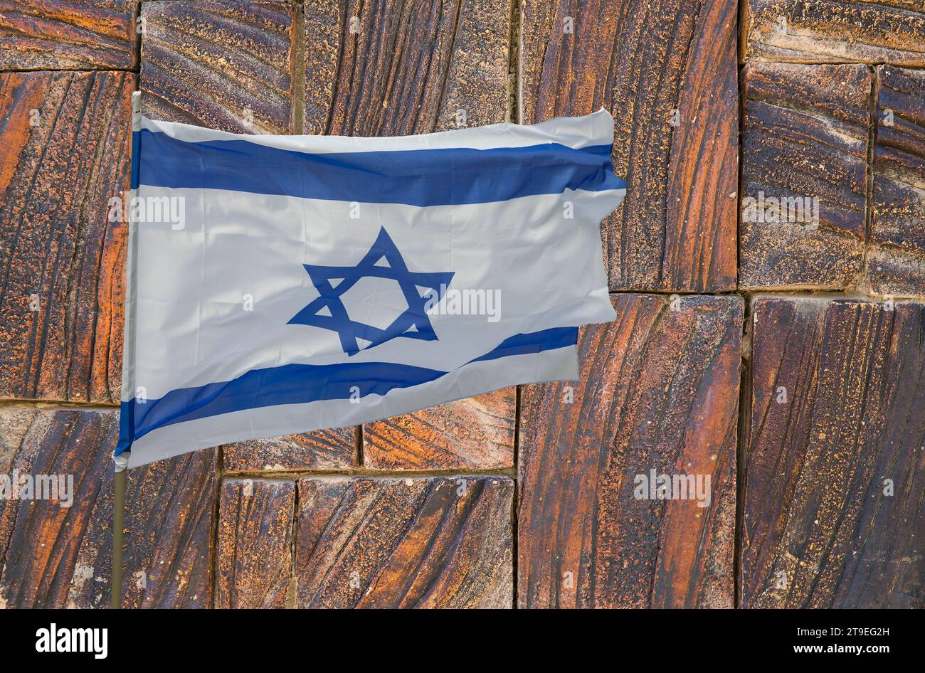 Bandiera israeliana sullo sfondo di un bel muro di pietra Foto Stock