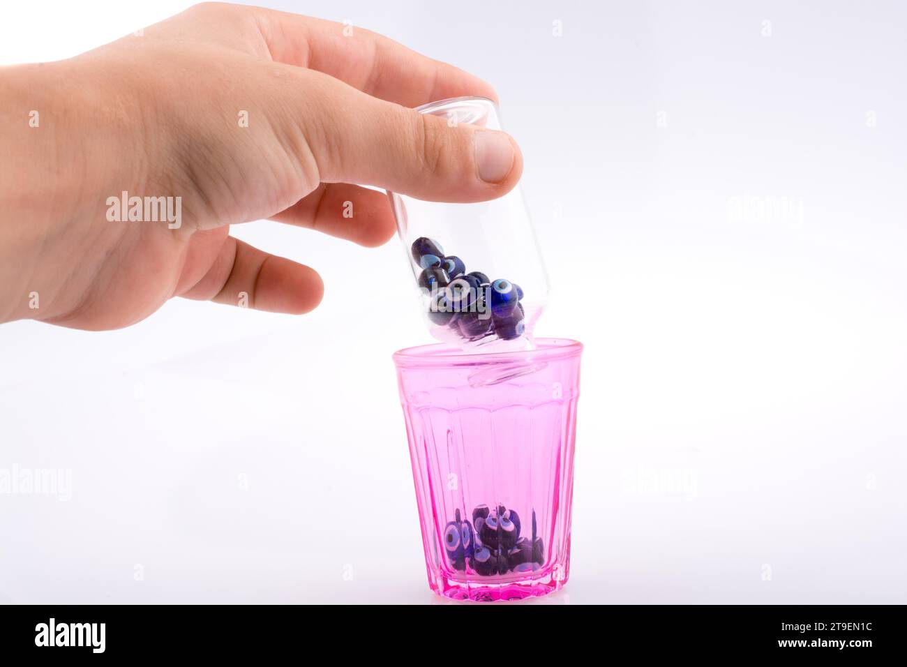 Piccola bottiglia di vetro con il perla dell'occhio malvagio blu in mano Foto Stock