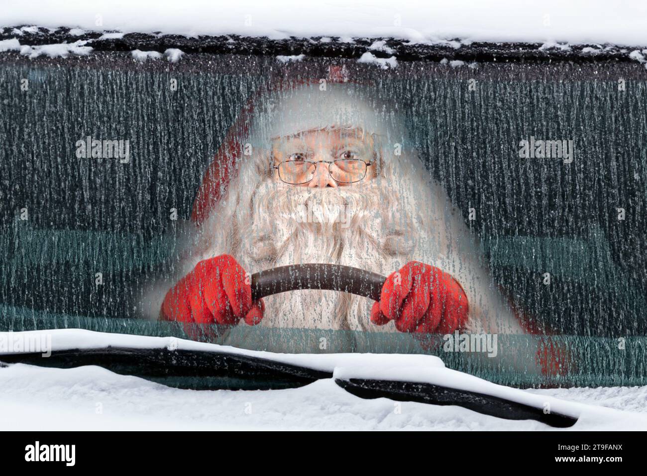 Babbo Natale guida un'auto innevata Foto Stock