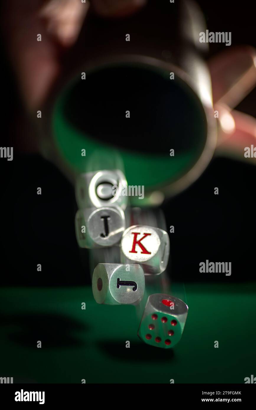 Dadi da poker americani che escono dalla tazza con effetto di movimento. Cattura l'intrigo e la suspense di un gioco in pieno sviluppo. Foto Stock