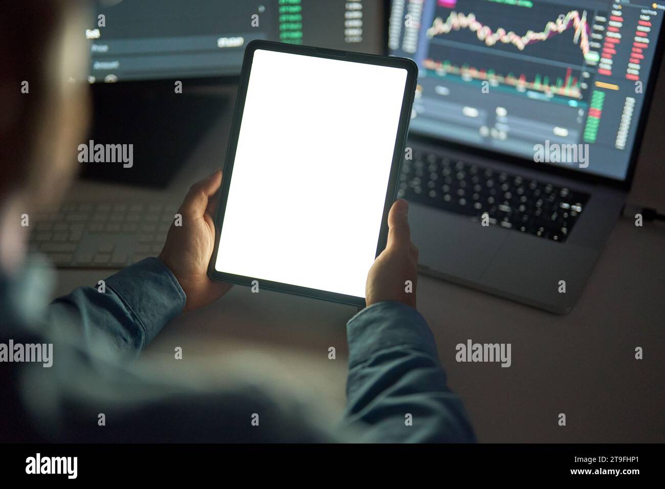 Uomo d'affari, trader che tiene un tablet che analizza il mercato azionario, finge uno schermo bianco. Foto Stock