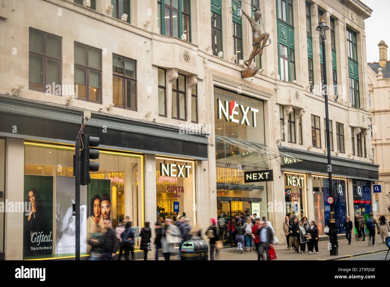 LONDRA - 23 NOVEMBRE 2023: Il prossimo flagship store e gli acquirenti di Motion Blurred su Oxford Street, punto di riferimento per la vendita al dettaglio Foto Stock