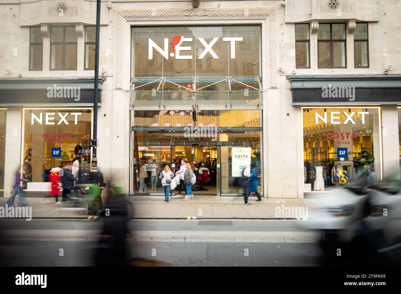 LONDRA - 23 NOVEMBRE 2023: Il prossimo flagship store e gli acquirenti di Motion Blurred su Oxford Street, punto di riferimento per la vendita al dettaglio Foto Stock
